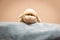 Closeup of a fluffy children`s sheep toy on top of a cozy blanket with a clear beige background