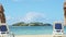 Closeup fluffy clouds fly above ocean and sand with beach chairs and closed umbrellas