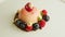 Closeup focus in at dessert finely decorated with berries rotates on plate