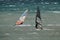 Closeup focus shot of two people windsurfing in the middle of the sea