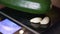 Closeup footage of a cucumber and two garlic cloves on a digital weight machine
