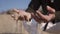 Closeup footage of a young man\'s hand full of sand throwing it around