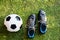 Closeup of football boots with a football on ground