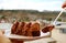 Closeup fork scooping mouthwatering chocolate and caramel mousse cake against blurry city aerial view