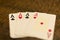 Closeup of four ace playing cards placed on a wooden table