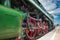 Closeup of four big red driving wheels of a steam locomotive