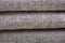 Closeup of a fragment of a beige textile sofa in the room. Texture of expensive fabric on furniture