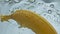 Closeup fresh banana water floating in light background. Yellow tropical fruit