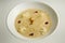 Closeup fresh beige seafood cream soup decorated with dried squid and soy sauce