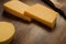 Closeup of fresh cheddar cheeses on a wooden table