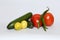 Closeup of fresh cucumbers, lemons, chilis, and tomatoes isolated on a white background