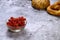 Closeup of the fresh and delicious redcurrants in a glass bowl on a gray surface