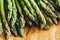 Closeup of fresh green asparagus on vintage wooden table. Cooking vegetarian food with organic ingredient on rustic board. Healthy