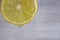Closeup of a fresh lemon slice with a drop of juice on gray defokus bekraund. Health concept.