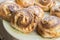 Closeup of freshly baked round homemade cinnamon rolls lying on a plate, top view, food and baking background
