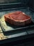 A closeup of a freshly steak with a background of labgrown meatproducing equipment.. AI generation