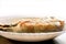 Closeup fried mackerels on white ceramic plate and wooden table with natural sun light background.