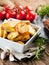 Closeup of fried rosemary potato wedges in a rustic setting..