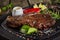 Closeup of fried veal entrecote on wooden board with condiments