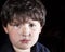 Closeup of Frightened Boy Against a Black Background