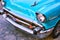 Closeup of the front of an aqua marine blue 1957 Chevrolet 150