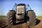 closeup front view wheels bonnet of tractor on ploughed field