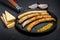 Closeup frying pan with fried thin sausages and granular mustard