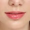 Closeup of full female lips with lip balm for moisturizing