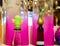 Closeup of fun wine cork stoppers in wine bottle tops in front of fushia vases in party setting