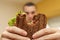 Closeup funny blurred protrait of young man hold bitten sandwich by his two hands. Sandwich in focus. light background