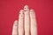 Closeup of a funny family face doodles on fingers against a red background