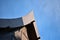 Closeup gable roof of traditional Thai style house with clear blue sky.