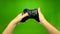 Closeup of gamer hands playing pressing joystick. Green screen