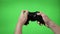 Closeup of gamer hands playing videogame pressing remote controller keys with chroma key background -