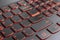 Closeup of gamer laptop keyboard red illumination, backlit keyboard, english letters