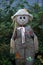 Closeup of a garden scarecrow on the green bushes background