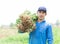 Closeup gardener man holding fresh raw peanut with happy face in the green field, selective focus