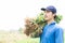 Closeup gardener man holding fresh raw peanut with happy face in the green field, selective focus