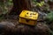 a closeup of a geocache with the iconic yellow smiley face and hidden treasure