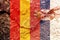 Closeup of Germany and Serbia flags painted on a weathered rock wall background