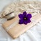 Closeup of a gift wrapped in brown paper with a violet flower