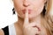 Closeup of girl with finger on lips asking for silence