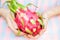 Closeup of girl`s hands with pitaya fruit. Exotic asian fruit.