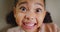 Closeup of a girl showing her teeth at a dentist check up. Orthodontist POV of playful little child smiling and feeling