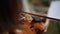Closeup of girls hand playing on violin. Music outside. Wedding ceremony