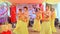 Closeup Girls in Yellow Costumes Dance on Stage at Wedding Party