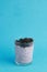 Closeup of a glass of chia pudding with blackberries against a blue background