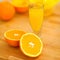 Closeup on glass of orange juice and oranges on cutting board