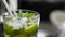 Closeup glass of unalcohol mohito cocktail with lime and mint and with a two tubes at bar background. Fresh drink for
