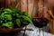 Closeup of glass of wine contrasted against a wooden background and a bowl of leafy greens